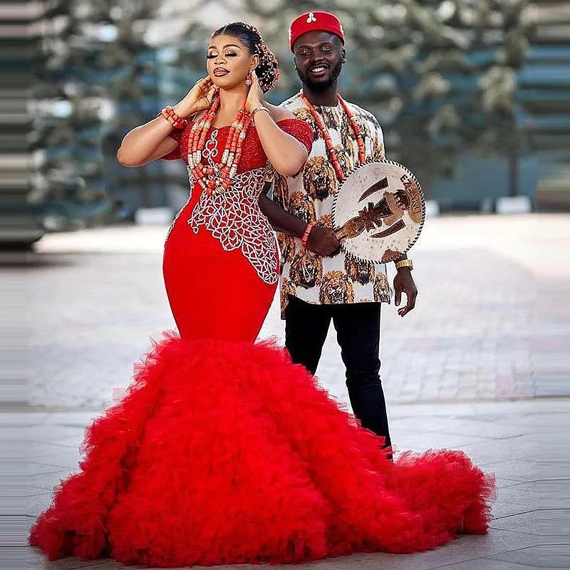 Model wearing a red mermaid prom dress, showcasing its fit and flare style.”